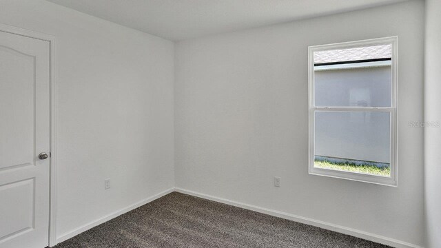 818 Grand Reserve Dr, Bunnell, FL 32110 - spare room with dark colored carpet and baseboards