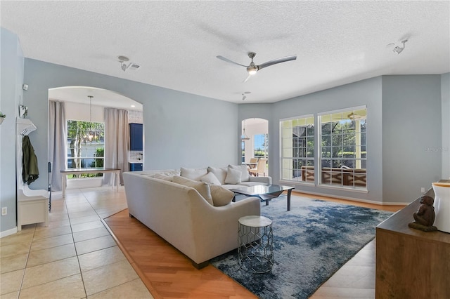 775 Blackmoor Gate Ln, Saint Augustine, FL 32084 - living room with arched walkways, a textured ceiling, ceiling fan, light tile patterned floors, and baseboards
