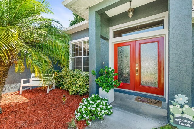 8 Buttermill Dr, Palm Coast, FL 32137 - view of exterior entry with stucco siding and french doors