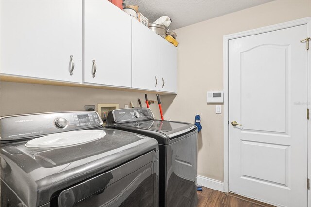 8 Buttermill Dr, Palm Coast, FL 32137 - washroom featuring cabinet space, washer and clothes dryer, dark wood-style flooring, and baseboards