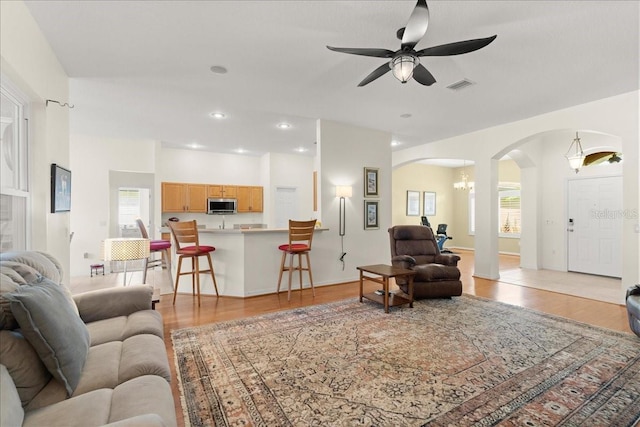 58 Slocum Path, Palm Coast, FL 32164 - living area with arched walkways, light wood-type flooring, a chandelier, ceiling fan, and recessed lighting
