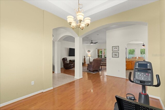 58 Slocum Path, Palm Coast, FL 32164 - workout area featuring ceiling fan, light wood-style floors, arched walkways, and a chandelier