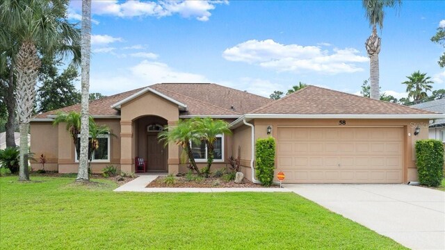 58 Slocum Path, Palm Coast, FL 32164 - ranch-style house featuring stucco siding, a garage, concrete driveway, and a front yard