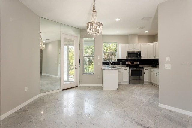 45 Atlantic Dr, Palm Coast, FL 32137 - kitchen featuring stainless steel appliances, a chandelier, baseboards, white cabinets, and light marble finish flooring