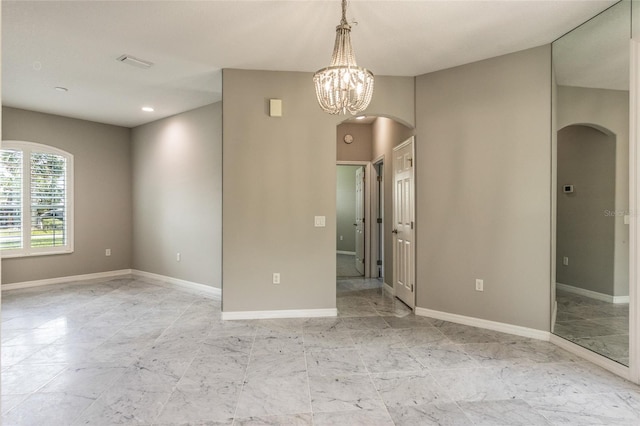 45 Atlantic Dr, Palm Coast, FL 32137 - empty room featuring arched walkways, baseboards, a chandelier, and recessed lighting