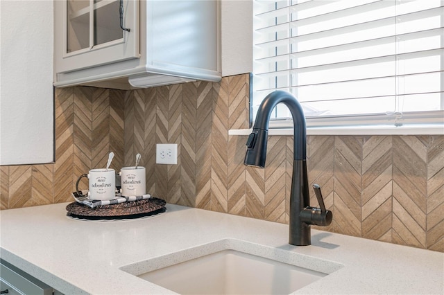 13 Las Brisas Way, Palm Coast, FL 32137 - kitchen view of a sink, tasteful backsplash, glass insert cabinets, and light stone countertops