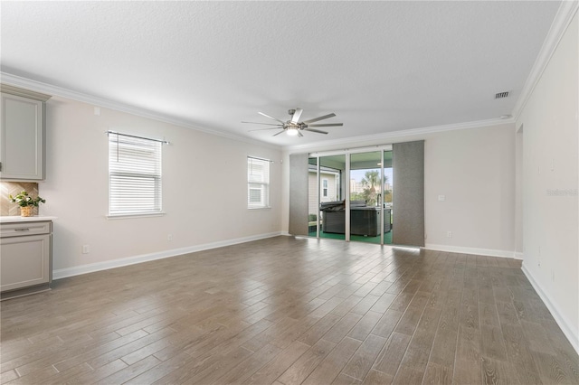13 Las Brisas Way, Palm Coast, FL 32137 - empty room featuring ornamental molding, light wood-type flooring, ceiling fan, baseboards, and a textured ceiling