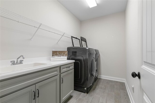 13 Las Brisas Way, Palm Coast, FL 32137 - laundry room with washer and dryer, cabinet space, light wood-style floors, and baseboards