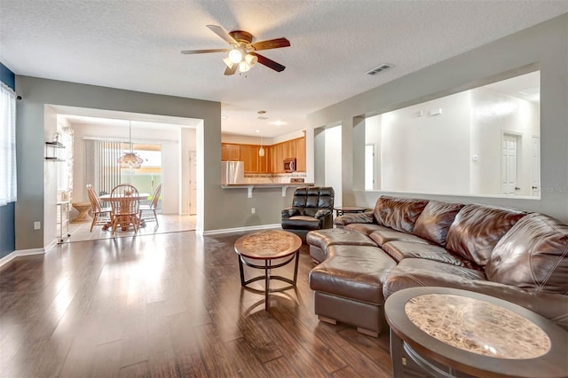 1 Rockwell Ln W, Palm Coast, FL 32164 - living room with dark wood-style floors, baseboards, a ceiling fan, and a textured ceiling