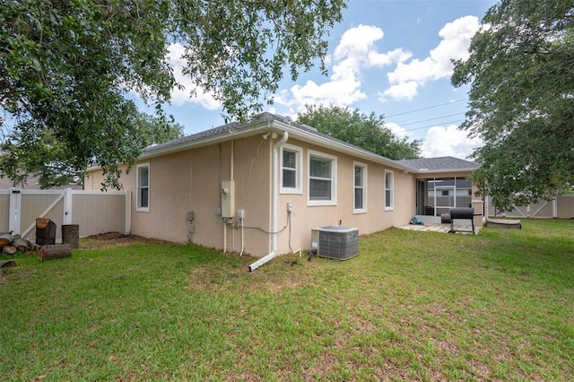 1 Rockwell Ln W, Palm Coast, FL 32164 - view of property exterior featuring stucco siding, a sunroom, and central AC