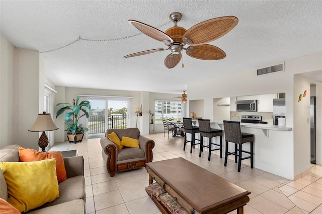 3600 S Ocean Shore Blvd Unit 222, Flagler Beach, FL 32136 - living area featuring a textured ceiling, a ceiling fan, and light tile patterned floors