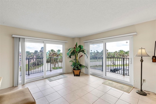 3600 S Ocean Shore Blvd Unit 222, Flagler Beach, FL 32136 - doorway to outside with a textured ceiling and light tile patterned floors