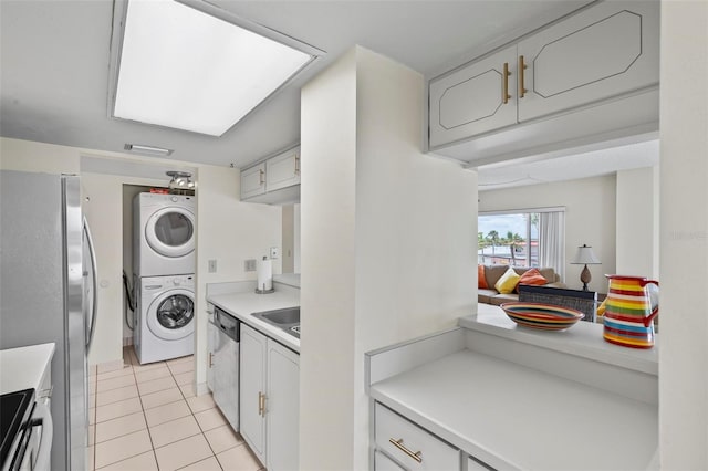 3600 S Ocean Shore Blvd Unit 222, Flagler Beach, FL 32136 - kitchen featuring estacked washer and dryer, appliances with stainless steel finishes, light tile patterned floors, and light countertops