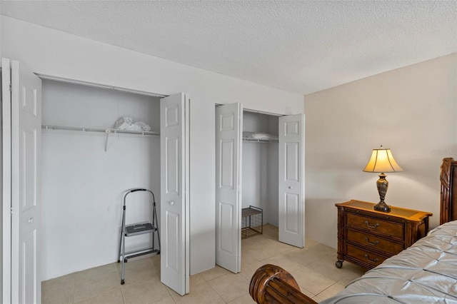 3600 S Ocean Shore Blvd Unit 222, Flagler Beach, FL 32136 - bedroom with two closets, light tile patterned flooring, and a textured ceiling