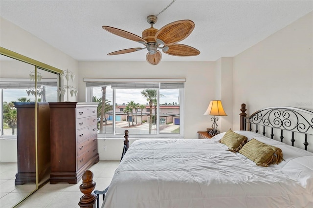3600 S Ocean Shore Blvd Unit 222, Flagler Beach, FL 32136 - bedroom featuring light tile patterned floors, ceiling fan, access to exterior, and a textured ceiling