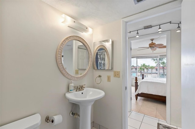3600 S Ocean Shore Blvd Unit 222, Flagler Beach, FL 32136 - ensuite bathroom featuring rail lighting, toilet, tile patterned floors, a sink, and ceiling fan