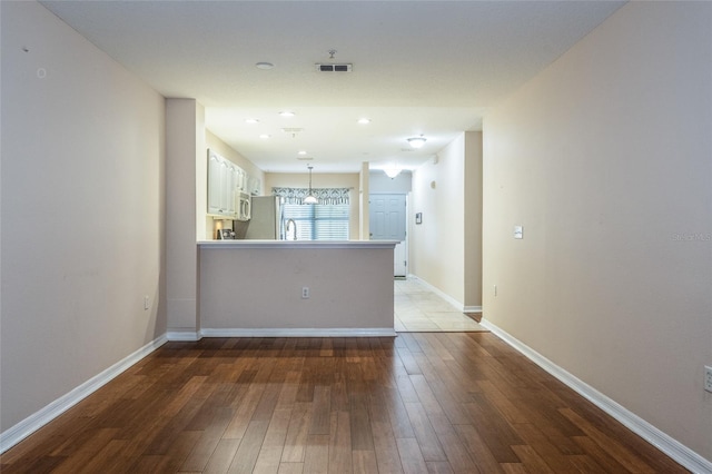 1100 Canopy Walk Ln Unit 1113, Palm Coast, FL 32137 - unfurnished living room with wood-type flooring, baseboards, and a sink