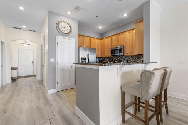 1200 Cinnamon Beach Way Unit 1133, Palm Coast, FL 32137 - kitchen with stainless steel appliances, a kitchen breakfast bar, tasteful backsplash, arched walkways, and a peninsula