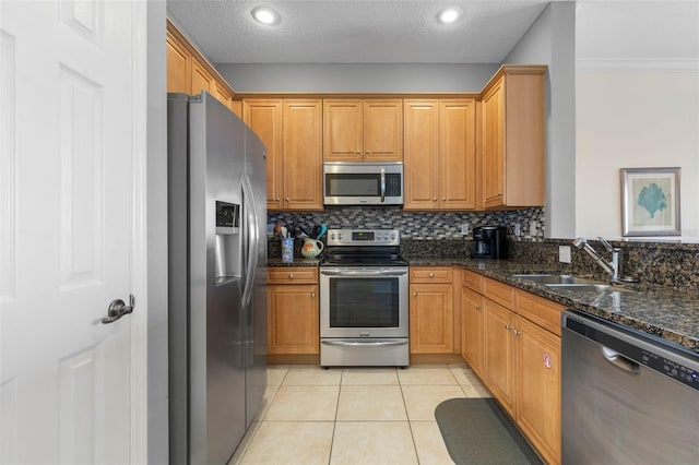1200 Cinnamon Beach Way Unit 1133, Palm Coast, FL 32137 - kitchen with appliances with stainless steel finishes, a sink, light tile patterned flooring, dark stone counters, and backsplash