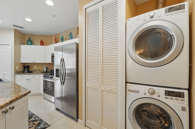 300 Via Castilla Unit 103, Saint Augustine, FL 32095 - laundry area featuring stacked washer and clothes dryer, light tile patterned floors, and recessed lighting