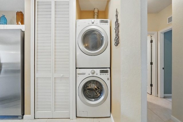 300 Via Castilla Unit 103, Saint Augustine, FL 32095 - laundry room with stacked washer / dryer, tile patterned floors, and baseboards