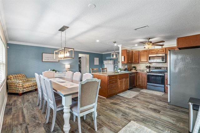 7 Fleming Ct, Palm Coast, FL 32137 - dining room featuring dark wood finished floors, ornamental molding, a ceiling fan, and a chandelier