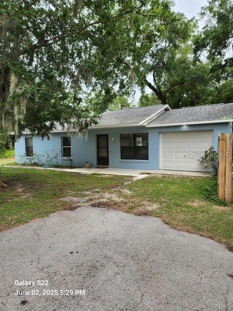 7686 SW 81st St, Ocala, FL 34476 - ranch-style house with an attached garage, stucco siding, roof with shingles, and a front yard