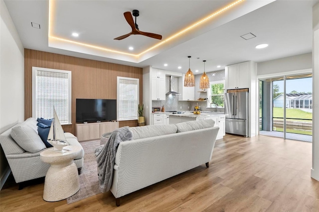 56 Columbia Ln, Palm Coast, FL 32137 - living area with light wood-style floors, ceiling fan, recessed lighting, and a tray ceiling