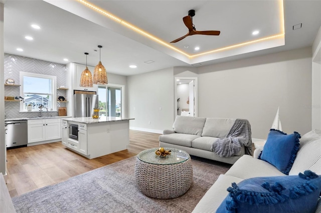 56 Columbia Ln, Palm Coast, FL 32137 - living area with light wood finished floors, a ceiling fan, recessed lighting, and a tray ceiling