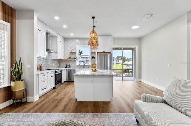 56 Columbia Ln, Palm Coast, FL 32137 - kitchen with stainless steel appliances, wall chimney exhaust hood, light wood-style floors, open shelves, and recessed lighting