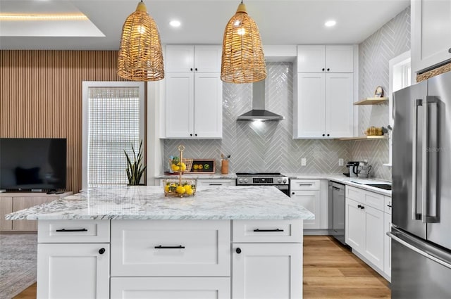 56 Columbia Ln, Palm Coast, FL 32137 - kitchen with appliances with stainless steel finishes, tasteful backsplash, wall chimney range hood, hanging light fixtures, and white cabinets
