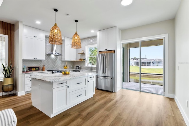 56 Columbia Ln, Palm Coast, FL 32137 - kitchen featuring stainless steel appliances, wall chimney exhaust hood, open shelves, pendant lighting, and tasteful backsplash