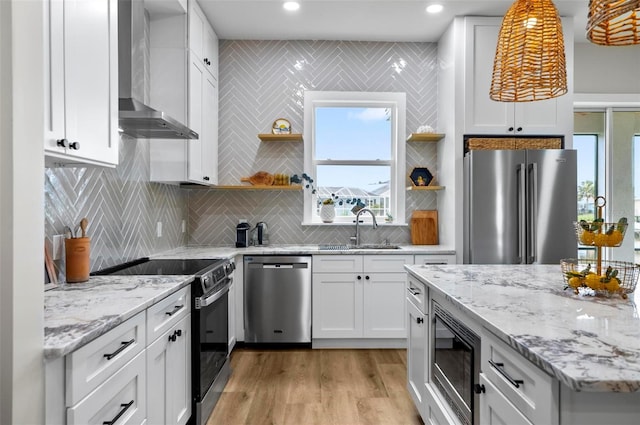 56 Columbia Ln, Palm Coast, FL 32137 - kitchen featuring stainless steel appliances, wall chimney exhaust hood, open shelves, white cabinetry, and light wood finished floors