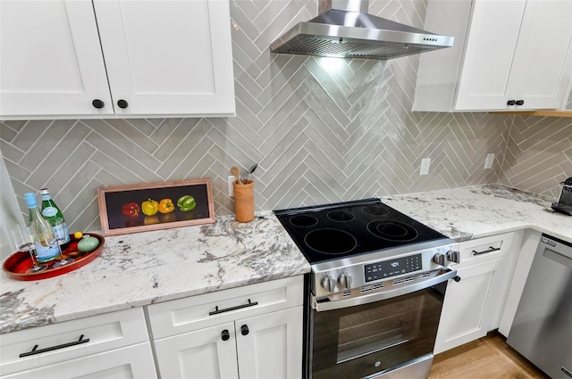 56 Columbia Ln, Palm Coast, FL 32137 - kitchen featuring appliances with stainless steel finishes, wall chimney range hood, tasteful backsplash, and white cabinets