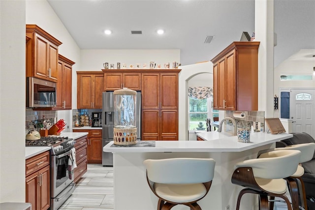 82 Ryland Dr, Palm Coast, FL 32164 - kitchen with stainless steel appliances, a peninsula, backsplash, light countertops, and recessed lighting