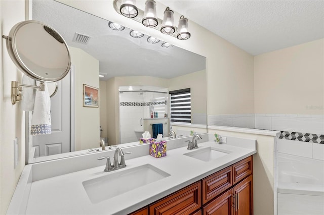82 Ryland Dr, Palm Coast, FL 32164 - bathroom with double vanity, a shower, a tub to relax in, a textured ceiling, and tile walls