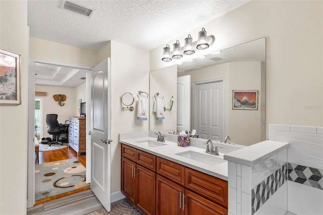 82 Ryland Dr, Palm Coast, FL 32164 - full bathroom featuring wood finished floors, double vanity, and a textured ceiling