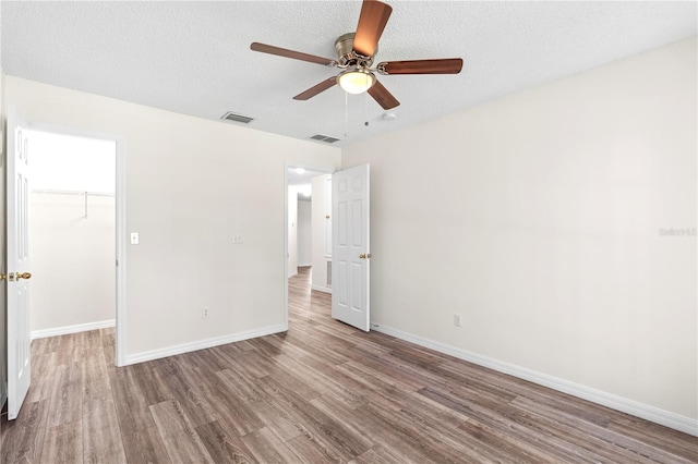 16 Flemington Ln, Palm Coast, FL 32137 - unfurnished bedroom with wood finished floors, a walk in closet, baseboards, a closet, and ceiling fan