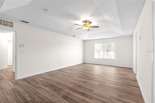 16 Flemington Ln, Palm Coast, FL 32137 - spare room with ceiling fan, wood finished floors, a textured ceiling, baseboards, and a raised ceiling