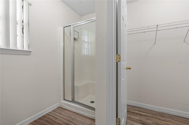 16 Flemington Ln, Palm Coast, FL 32137 - full bath featuring a stall shower, wood finished floors, a walk in closet, and baseboards