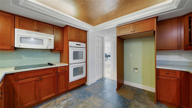 1 John Anderson Dr Unit 2180, Ormond Beach, FL 32176 - kitchen with white appliances, a tray ceiling, decorative backsplash, baseboards, and light countertops