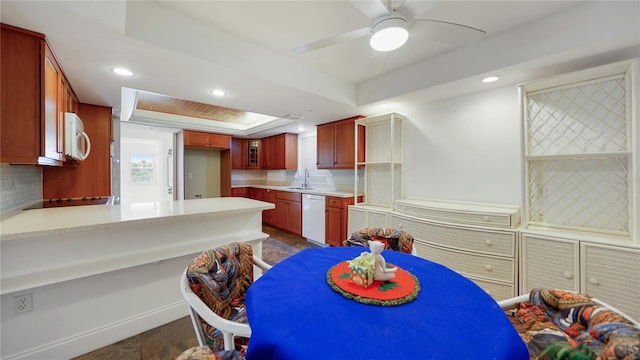 1 John Anderson Dr Unit 2180, Ormond Beach, FL 32176 - kitchen with a raised ceiling, white appliances, decorative backsplash, dark stone finish floors, and light countertops