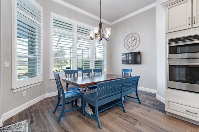 514 Wingspan Dr, Ormond Beach, FL 32174 - dining room featuring ornamental molding, a chandelier, baseboards, plenty of natural light, and dark wood finished floors