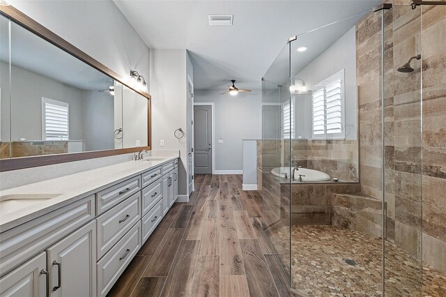 514 Wingspan Dr, Ormond Beach, FL 32174 - full bathroom featuring ceiling fan, double vanity, a garden tub, a stall shower, and wood finished floors