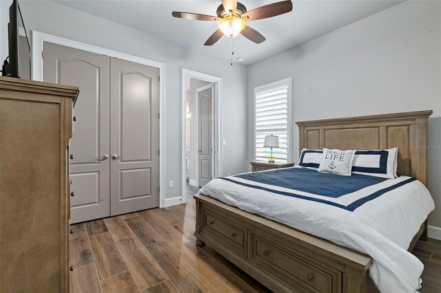 514 Wingspan Dr, Ormond Beach, FL 32174 - bedroom featuring dark wood-style flooring, baseboards, ensuite bath, a ceiling fan, and a closet
