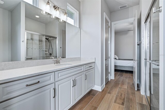 514 Wingspan Dr, Ormond Beach, FL 32174 - ensuite bathroom with vanity, a shower stall, wood finish floors, and baseboards