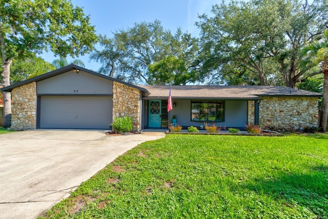 35 Whippoorwill Ln, Ormond Beach, FL 32174 - mid-century modern home with stone siding, a garage, concrete driveway, and a front lawn