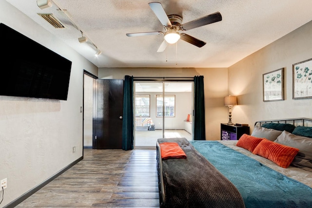 35 Whippoorwill Ln, Ormond Beach, FL 32174 - bedroom with wood finished floors, a textured ceiling, baseboards, and a ceiling fan