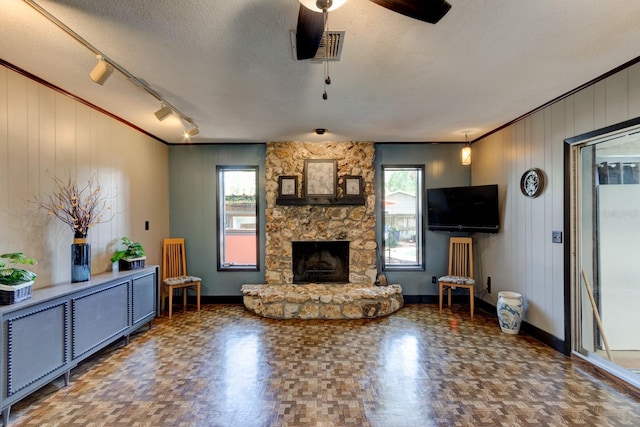 35 Whippoorwill Ln, Ormond Beach, FL 32174 - living room featuring baseboards, a fireplace, ceiling fan, track lighting, and a textured ceiling