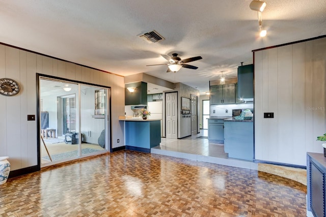 35 Whippoorwill Ln, Ormond Beach, FL 32174 - unfurnished living room with a textured ceiling, a ceiling fan, and baseboards